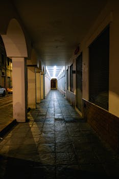 A moody, dimly lit alleyway in Cuenca, Ecuador, featuring classic architecture.